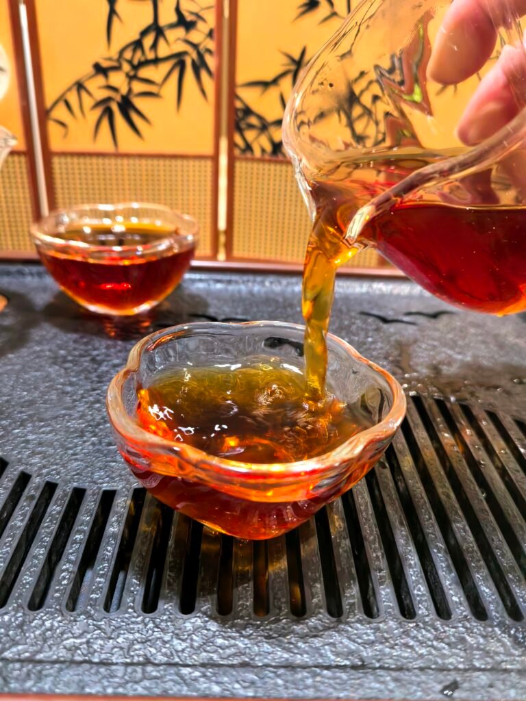 Premium Jin Junmei Golden Tea Liquor Pouring a cup of premium golden Jin Junmei black tea from Fujian.