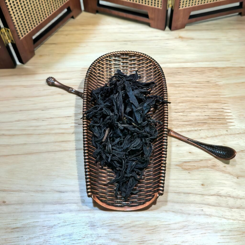High-mountain spring harvest Jin Mu Dan tea leaves resting on a bamboo scoop.