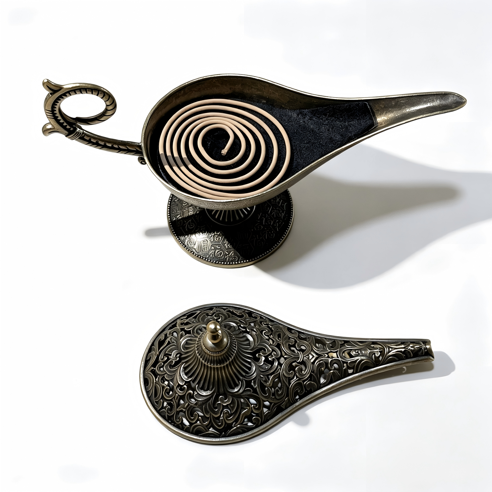 An overhead exploded view of the antique bronze Aladdin lamp incense burner, showcasing the open ash basin layered with fine black incense sand, the detached intricate filigree lid, and a natural brown coil incense beneath on a pure white background.