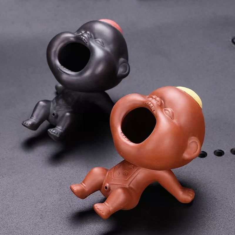 The Giggling Stream Zisha and Zhu Ni water-spitting tea pet pair displayed on a wet cha pan