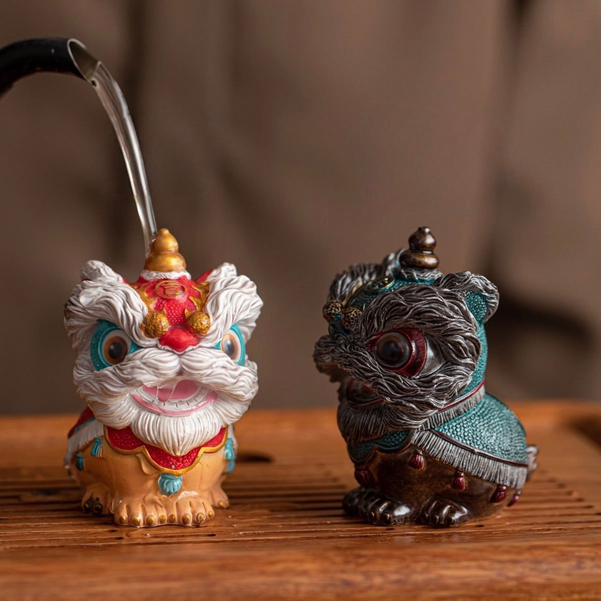 Pouring hot water onto a Chinese lion dance tea pet to reveal its vibrant white, red, and teal color-changing effect