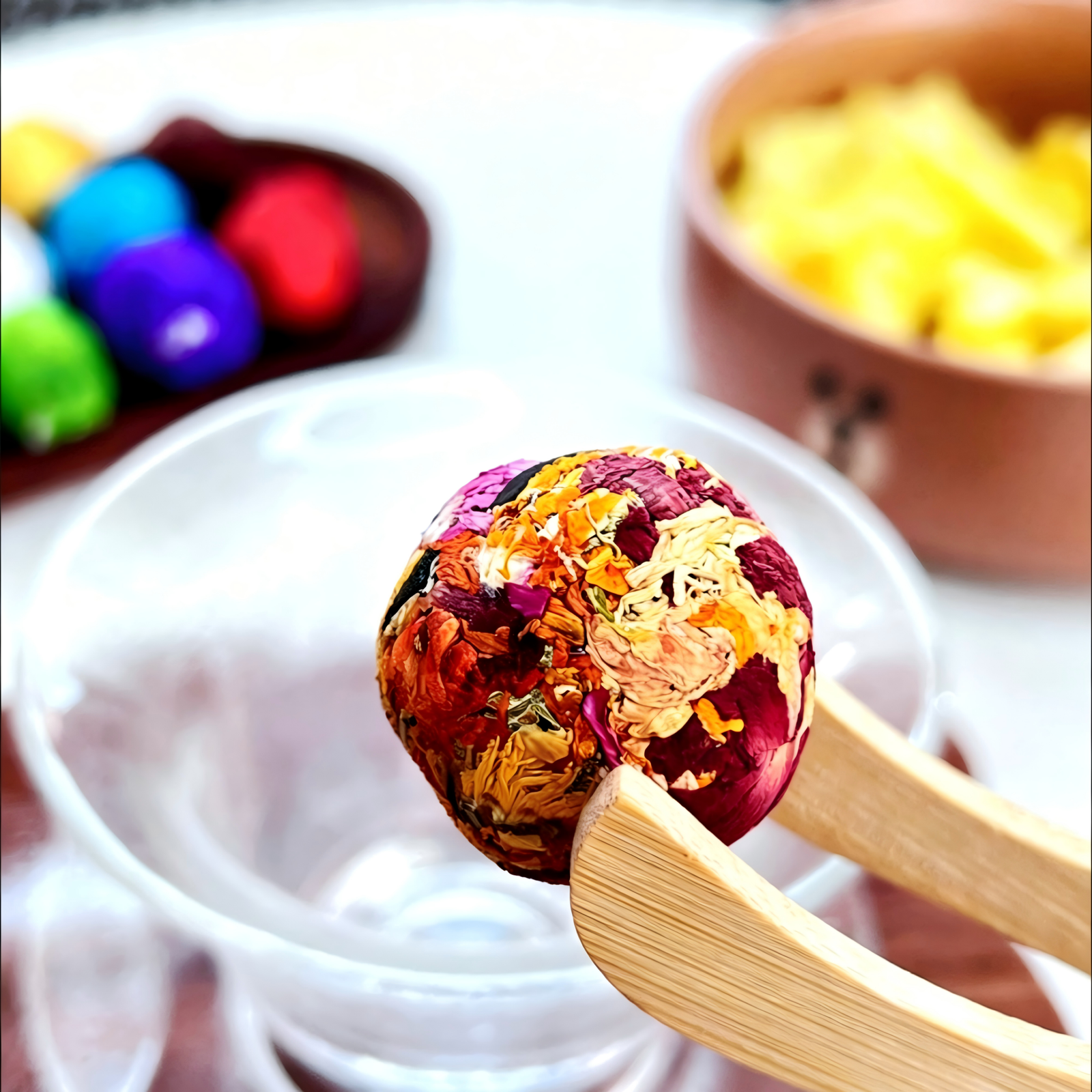 Vibrant Hundred Flowers herbal tea blend blooming in a glass teapot