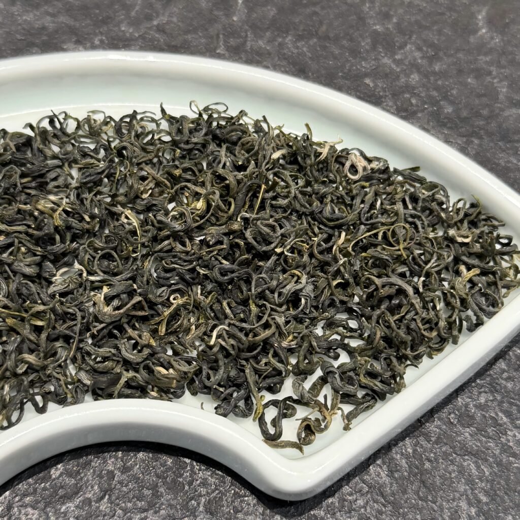Hand-rolled spiral leaves of authentic Dongting biluochun green tea displaying delicate white downy hairs.