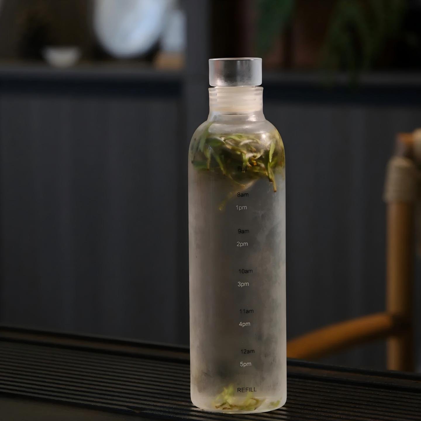 Glass pitcher of cold brewed white tea with fresh Shouning tea leaves on wooden table