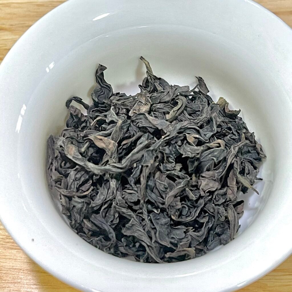 Brewed Wuyi rock tea served in a gaiwan with dry Sanyang Peak Rougui leaves